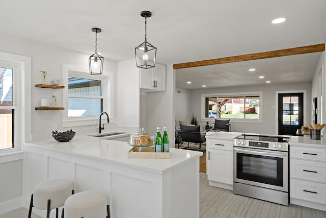 kitchen with electric stove, a peninsula, a sink, and white cabinetry