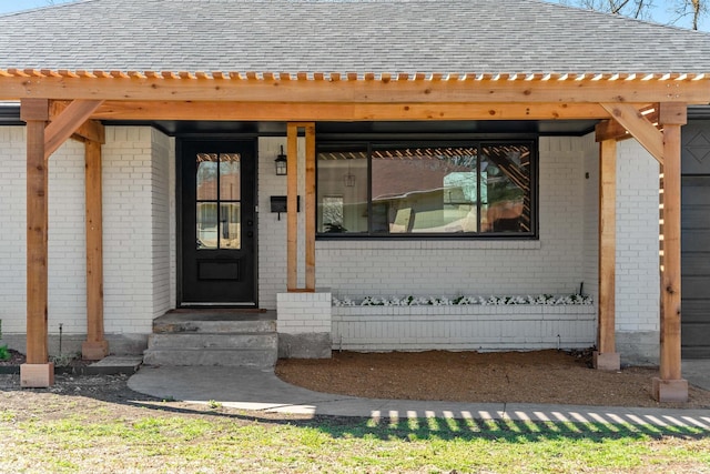 entrance to property with brick siding and roof with shingles