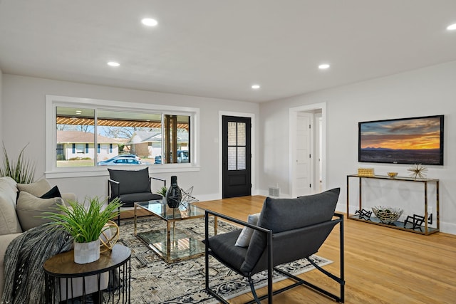 living room with recessed lighting, visible vents, light wood-style flooring, and baseboards