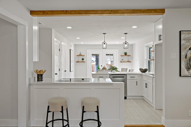 kitchen with black electric cooktop, a peninsula, white cabinetry, dishwasher, and a kitchen bar