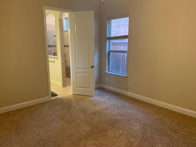 empty room with baseboards and light carpet