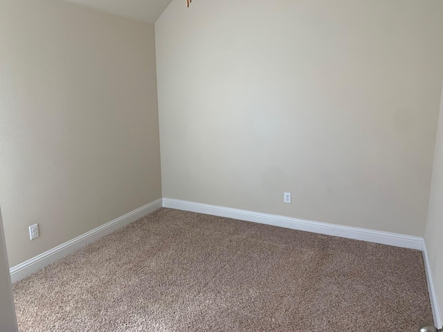 spare room featuring carpet flooring and baseboards