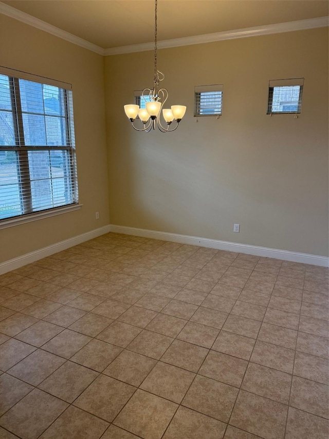 spare room with baseboards, a notable chandelier, and crown molding