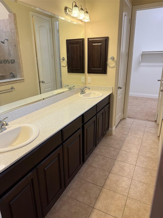 full bath with tile patterned floors, double vanity, and a sink