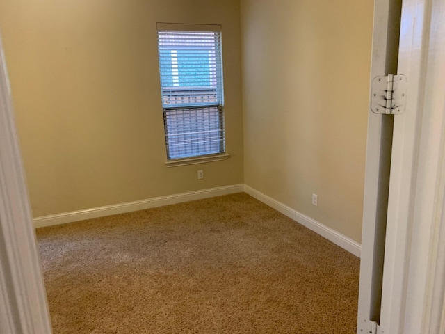 unfurnished room featuring carpet flooring and baseboards