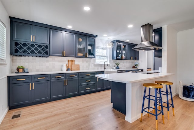 13660 Purple Sage Rd, Dallas, TX 75240 - kitchen with black electric cooktop, a breakfast bar, visible vents, light wood finished floors, and island exhaust hood