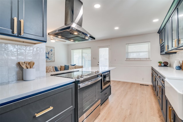 13660 Purple Sage Rd, Dallas, TX 75240 - kitchen with stainless steel electric range oven, light wood finished floors, light countertops, backsplash, and ventilation hood