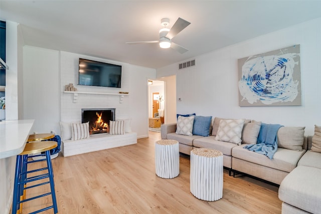 13660 Purple Sage Rd, Dallas, TX 75240 - living area with a fireplace, wood finished floors, visible vents, and a ceiling fan