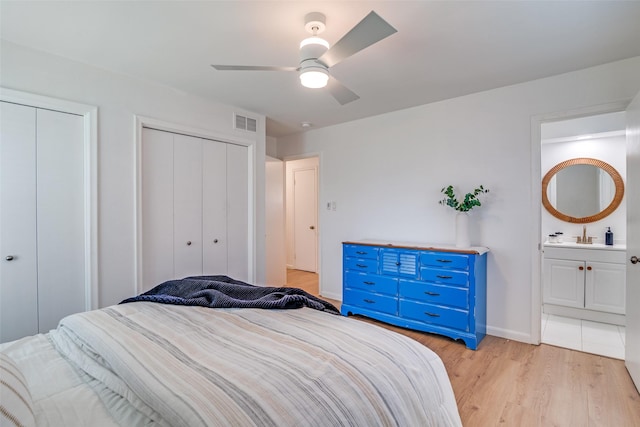 13660 Purple Sage Rd, Dallas, TX 75240 - bedroom with light wood finished floors, visible vents, baseboards, a ceiling fan, and two closets