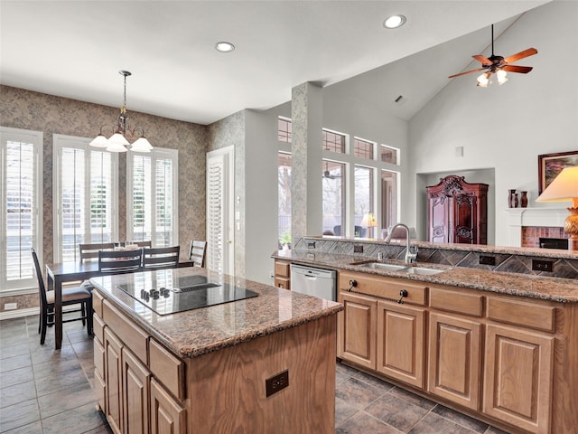 kitchen with stone counters, stainless steel dishwasher, black electric cooktop, and a sink