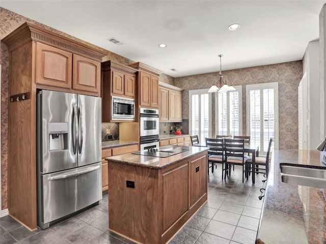 kitchen featuring a sink, visible vents, appliances with stainless steel finishes, and wallpapered walls