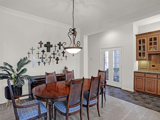 dining space featuring dark tile patterned floors, ornamental molding, dark carpet, french doors, and baseboards