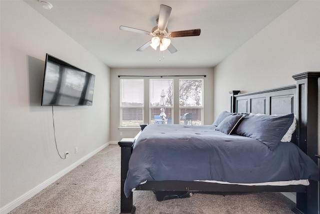 carpeted bedroom with ceiling fan and baseboards