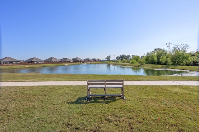 view of home's community with a water view and a yard