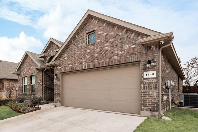 view of front facade featuring a garage, driveway, cooling unit, and brick siding