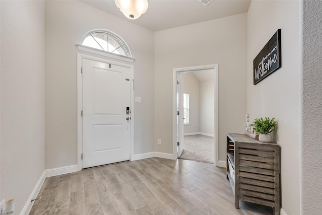 foyer with light wood-style flooring and baseboards