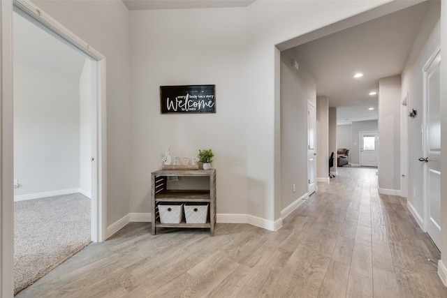 hallway featuring recessed lighting, light wood-style flooring, and baseboards