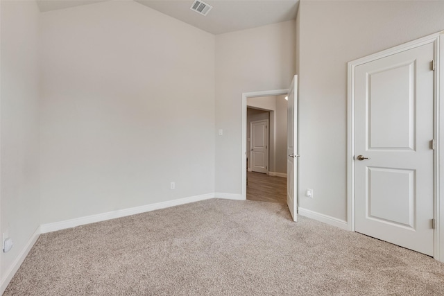 unfurnished bedroom with carpet floors, baseboards, and visible vents