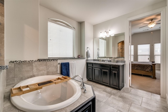 ensuite bathroom with ensuite bathroom, a tub to relax in, tile patterned flooring, vanity, and a ceiling fan