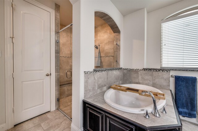 full bathroom featuring a garden tub, a shower stall, and tile patterned flooring