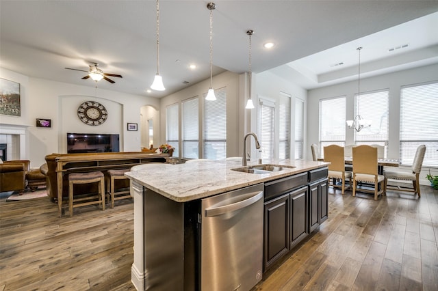 kitchen with a sink, visible vents, open floor plan, stainless steel dishwasher, and dark wood finished floors