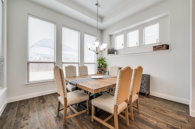 dining area with dark wood-type flooring, visible vents, a notable chandelier, and baseboards