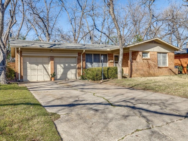 ranch-style home featuring a garage, a front yard, brick siding, and driveway