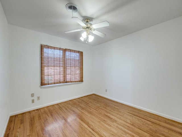 empty room featuring light wood-style floors, visible vents, baseboards, and a ceiling fan