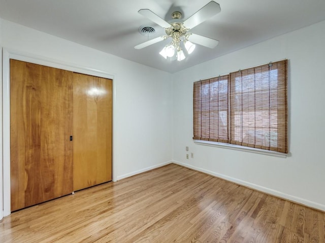 unfurnished bedroom featuring light wood-style floors, a closet, visible vents, and baseboards