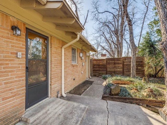 exterior space with brick siding and fence