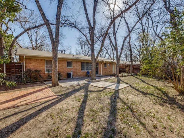 back of property with fence, cooling unit, and brick siding