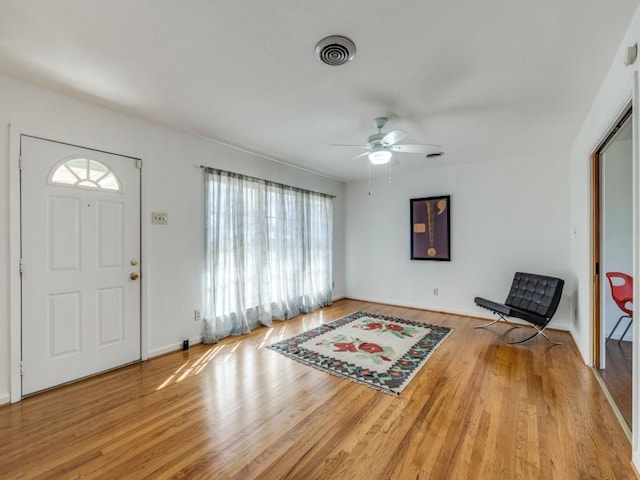 foyer with visible vents, ceiling fan, baseboards, and wood finished floors