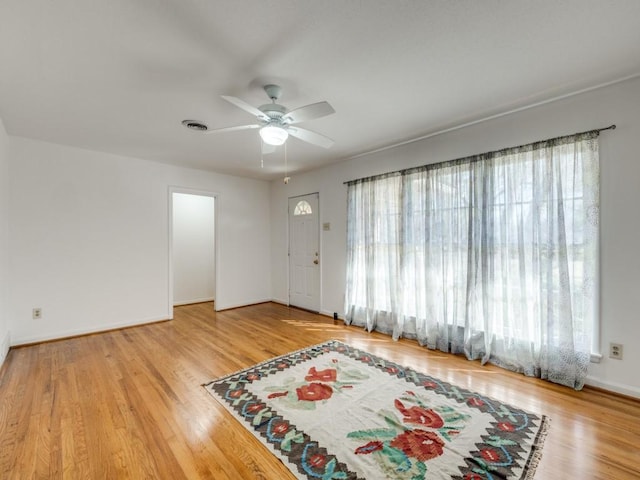 interior space featuring visible vents, wood finished floors, a ceiling fan, and baseboards