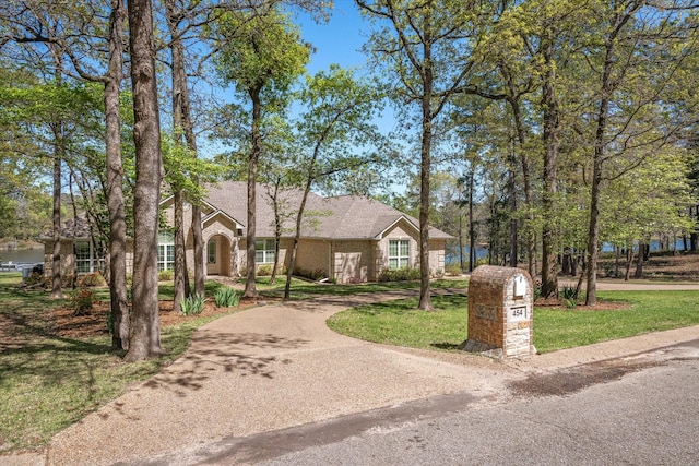 view of front of home with aphalt driveway and a front lawn