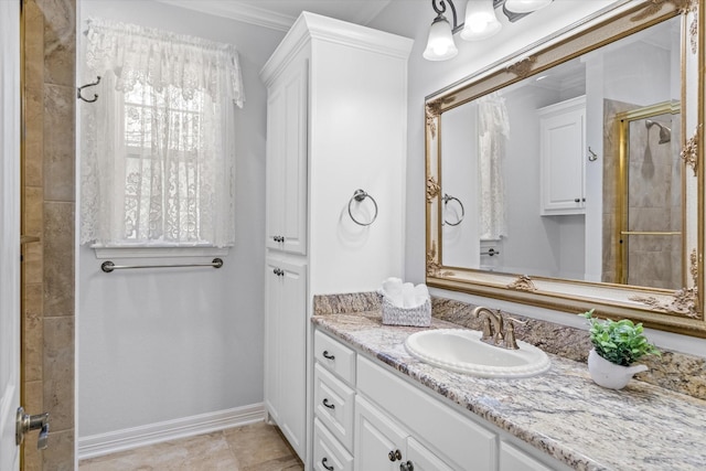 bathroom featuring a tile shower, vanity, and baseboards