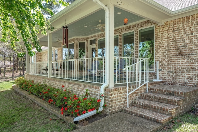 view of exterior entry with a porch and brick siding