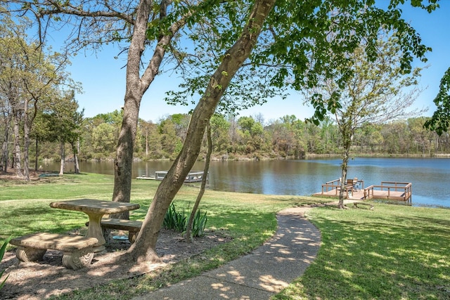 view of community featuring a water view and a yard