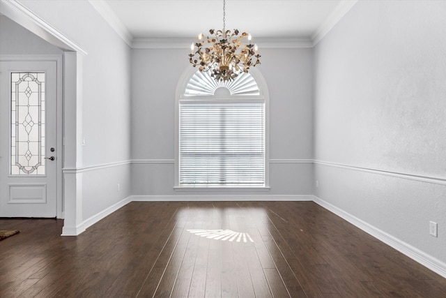 foyer entrance featuring dark wood-style flooring, crown molding, and an inviting chandelier