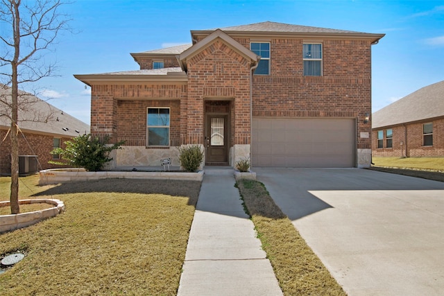 traditional home featuring brick siding, a front yard, a garage, stone siding, and driveway