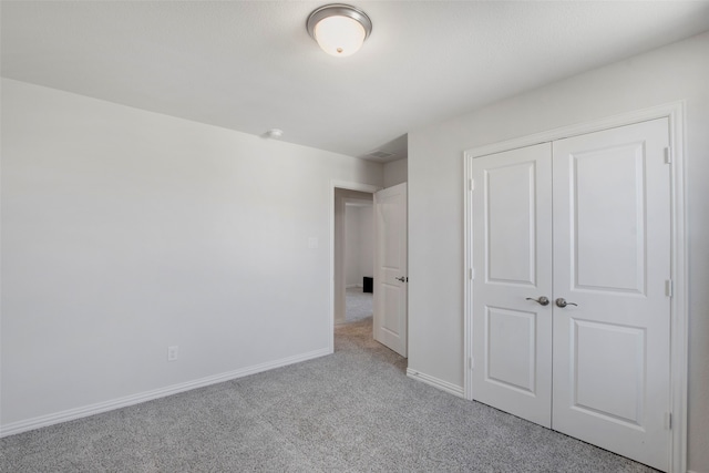 unfurnished bedroom with a closet, carpet, and baseboards