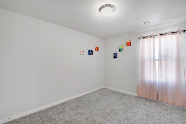 unfurnished room featuring carpet, visible vents, and baseboards