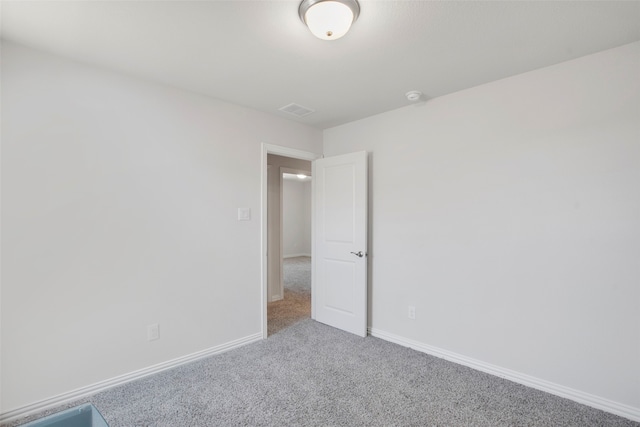 carpeted empty room featuring visible vents and baseboards