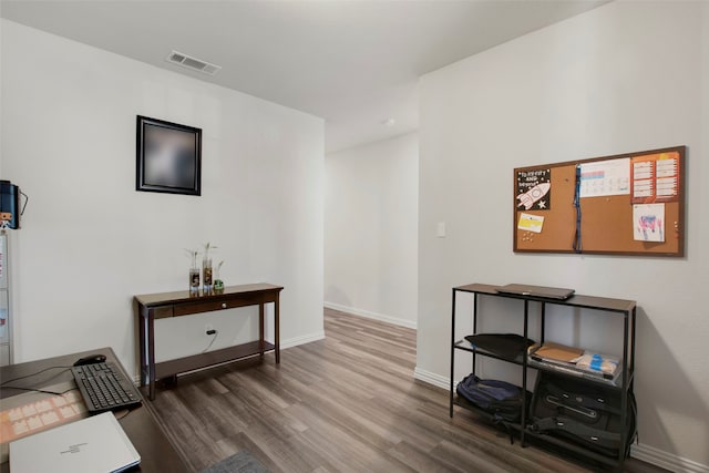 interior space featuring visible vents, baseboards, and wood finished floors