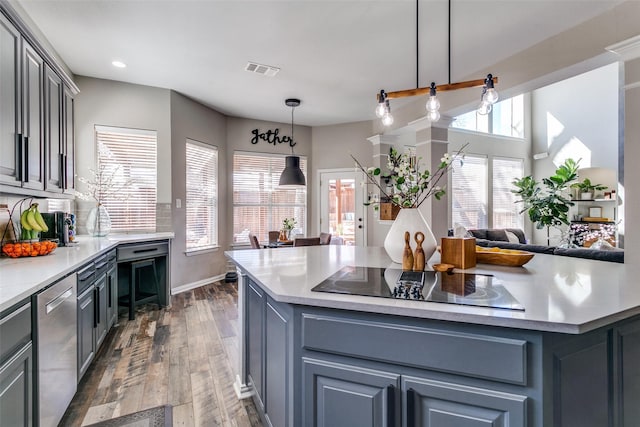 kitchen featuring black electric stovetop, visible vents, stainless steel dishwasher, gray cabinetry, and a healthy amount of sunlight