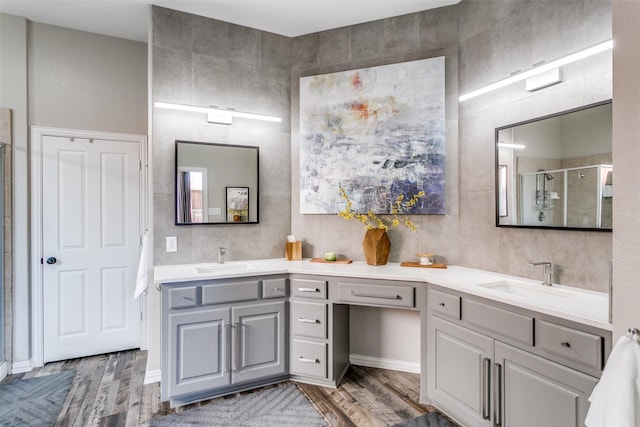 full bath with a stall shower, wood finished floors, and vanity