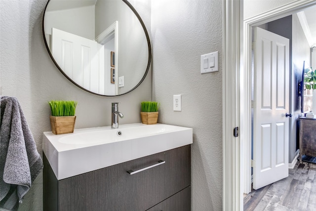 bathroom featuring a textured wall, vanity, and wood finished floors