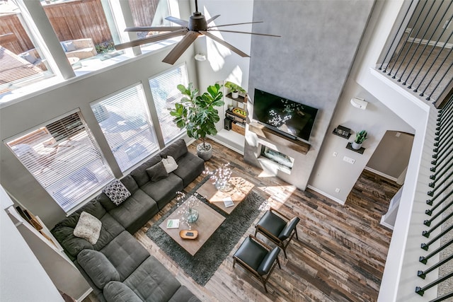 living area with a high ceiling, stairway, and wood finished floors