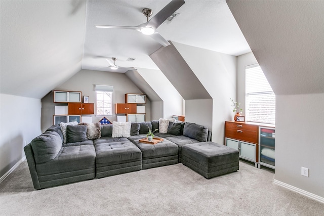 carpeted living room with a ceiling fan, visible vents, vaulted ceiling, and baseboards