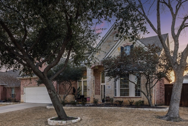 view of front of home with stone siding, brick siding, and driveway