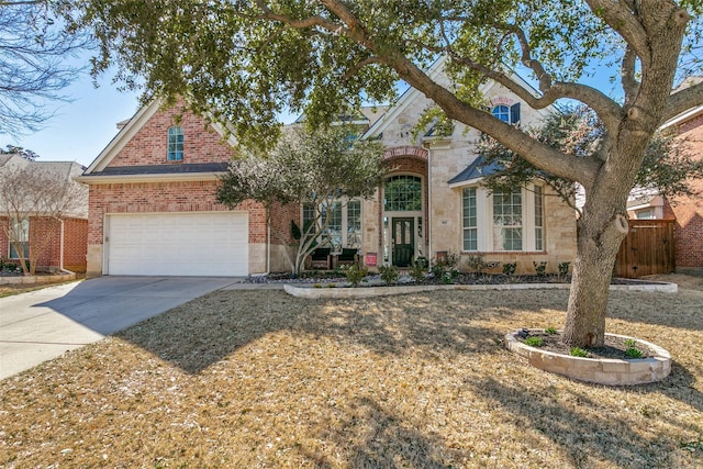 traditional home with stone siding, brick siding, fence, and concrete driveway